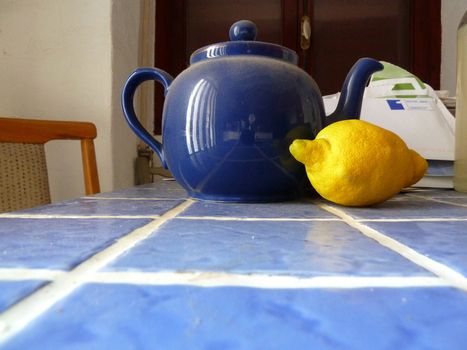 dusty blue teapot with a lemon as a background
