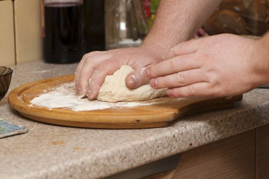 man kneading dough for pizzas