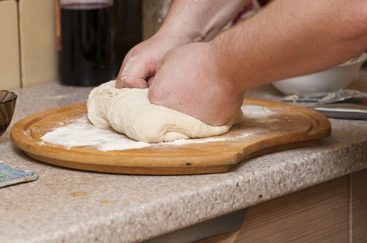 man kneading dough for pizzas