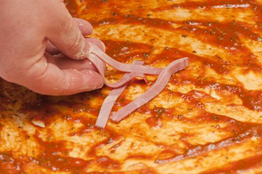 chef puts ham on the pizza