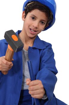 A kid dressed as a construction worker with a hammer.
