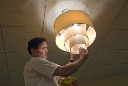 Changing light bulb in commercial building