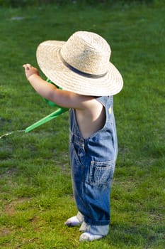 A boy with straw hat, a young gardener enjoying the spring