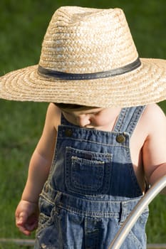 A boy with straw hat, a young gardener enjoying the spring