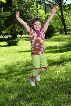 happy little girl jumping in park