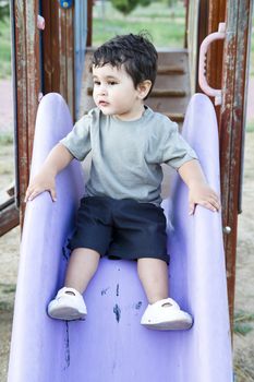 Cute baby playing on sliding board