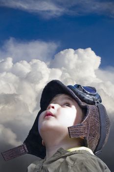 A child dressed in pilot looking into the blue sky