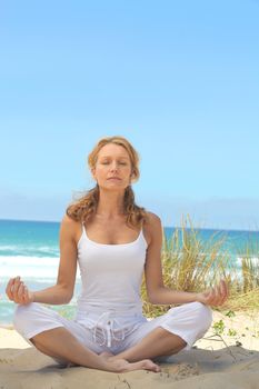 Woman meditating on a beach