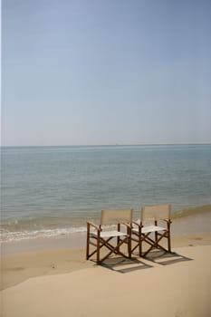 Two empty chairs on a beach