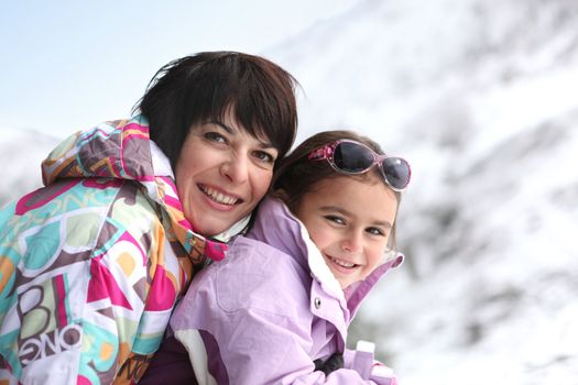 Mother and daughter on snowy mountain