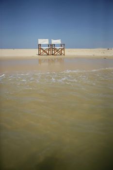 Two director's chairs on a beach