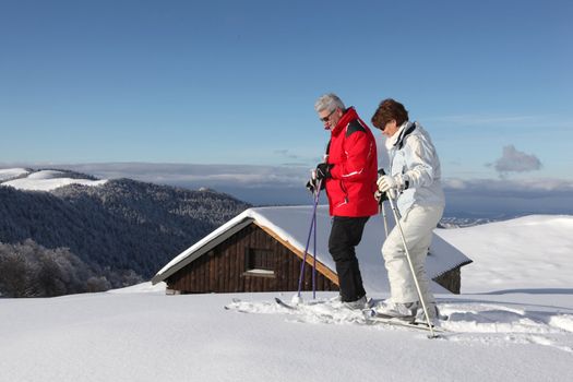 Skiing couple in front of chalet