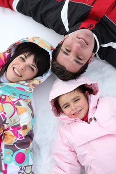 Family lying in the snow