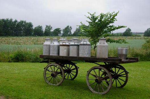 old traditional milk cans on a wooden horse and cart