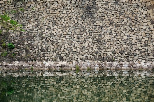 Strong castle fortification wall mirrored in water