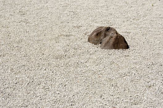 Stone garden of Zen Buddhism in Japan with gravel and one big stone