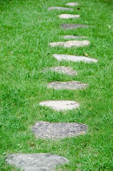 Stepping stones in a green meadow in a garden
