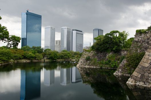 The Skyline of Osaka Business Park with the fortification walls of Osaka castle in the foreground