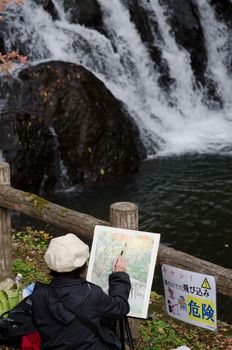 Women painting outdoors in front of a water fall
