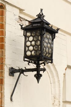 Grunge retro metal decorative lighting on old wall of house in old town.