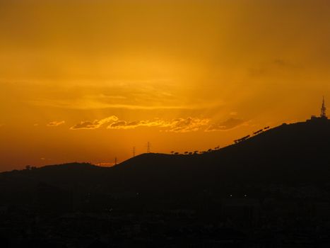 Sunset over the hills of Barcelona with yellow sky