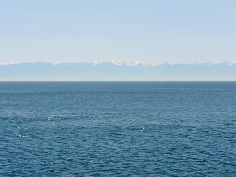 wide view over the sea with mountains in the background
