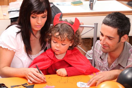 little girl dressed as a devil drawing