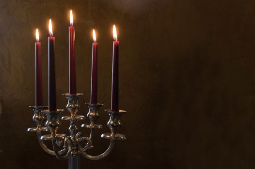 Five red candles lighted on brown painted room