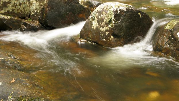 water flow around stones in a small river in australia, water fall