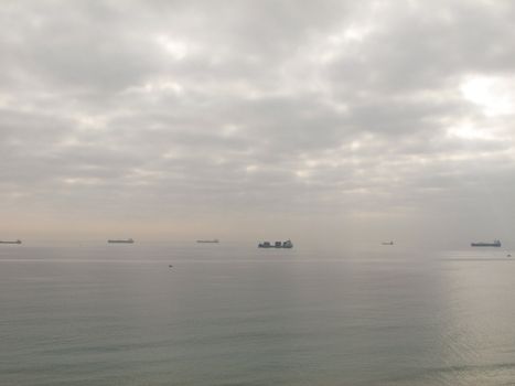 cargo ships waiting in front of a harbor in spain