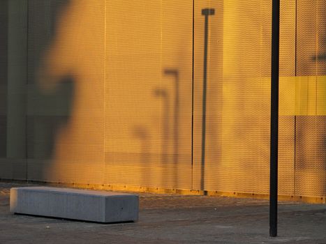street lights, bench and wall in warm sunlight 