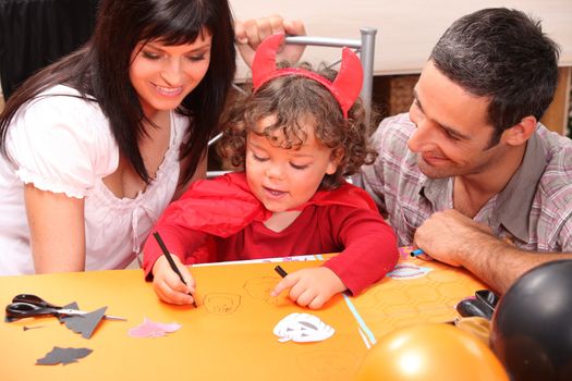 Little boy in Halloween costume with his parents