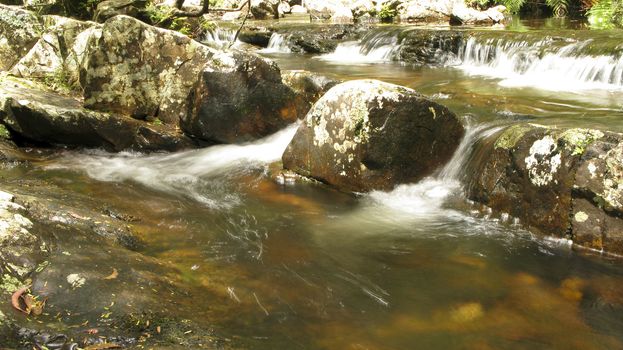 water flow around stones in a small river in australia, water fall