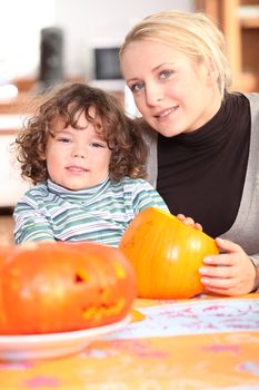Woman carving pumpkins with her child