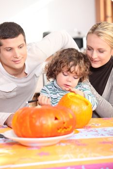 Parents and daughter in the kitchen preparing pumpkin