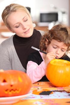 Little girl carving out pumpkin for Halloween