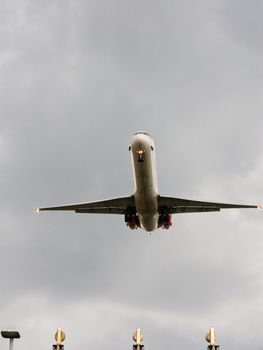 Landing airplane with cloudy sky in background