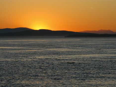 Sunset over the pacific with mountain range in background