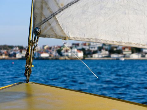 view on the tip of a sailing boat with a city in the background