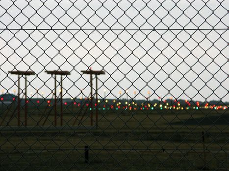 airfield, landing field of an airport seen trough a fence
