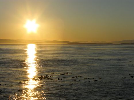 Sunset over the pacific with mountain range in background