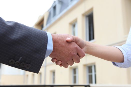 Close-up of man and woman shaking-hands outdoors