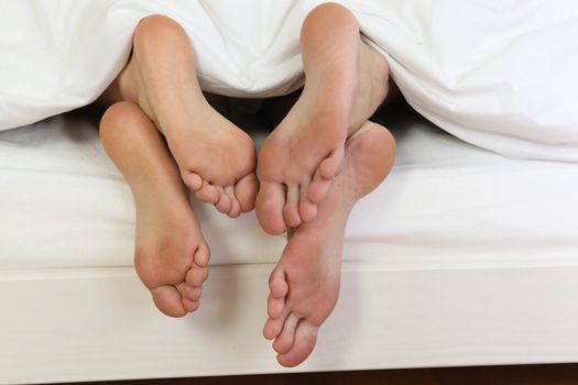 Bare feet at the end of a bed