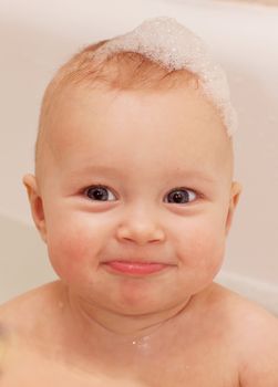 Adorable bath baby with soap suds on hair