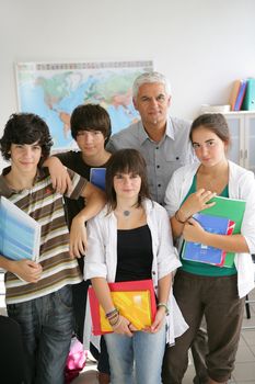 Teenagers standing with their teacher in a classroom