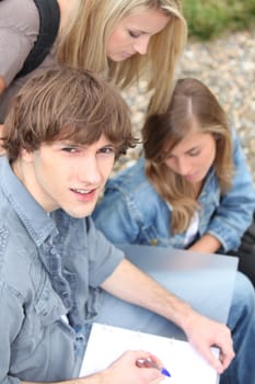 Young students outside with coursework