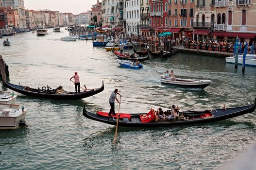 ITALY, VENICE - AUG 21: Gondolas with tourists cruising a small Venetian canal on August 18, 2011 in Venice. Gondola is a major mode of touristic transport in Venice, Italy.
