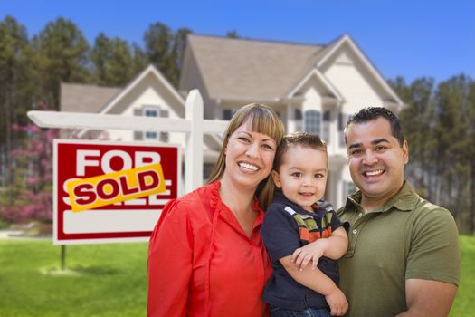 Mixed Race Young Family in Front of Sold Home For Sale Real Estate Sign and New House.