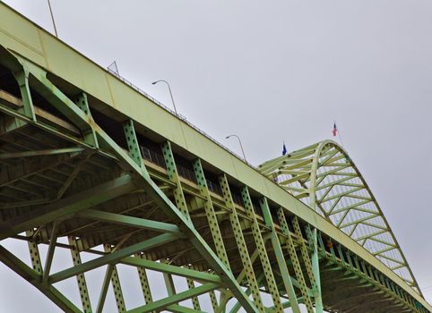 Old Steel bridge from bottom looking up towards gray and cloudy sky