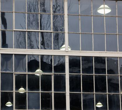 Diagonal traversing warehouse ceiling lights as seen through exterior window
